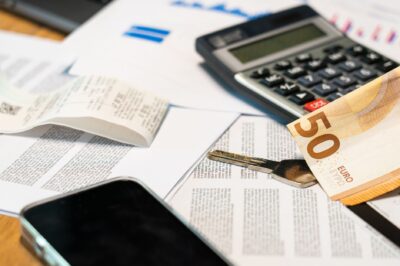 Billets en euros, calculatrice et clé de voiture posés sur une table