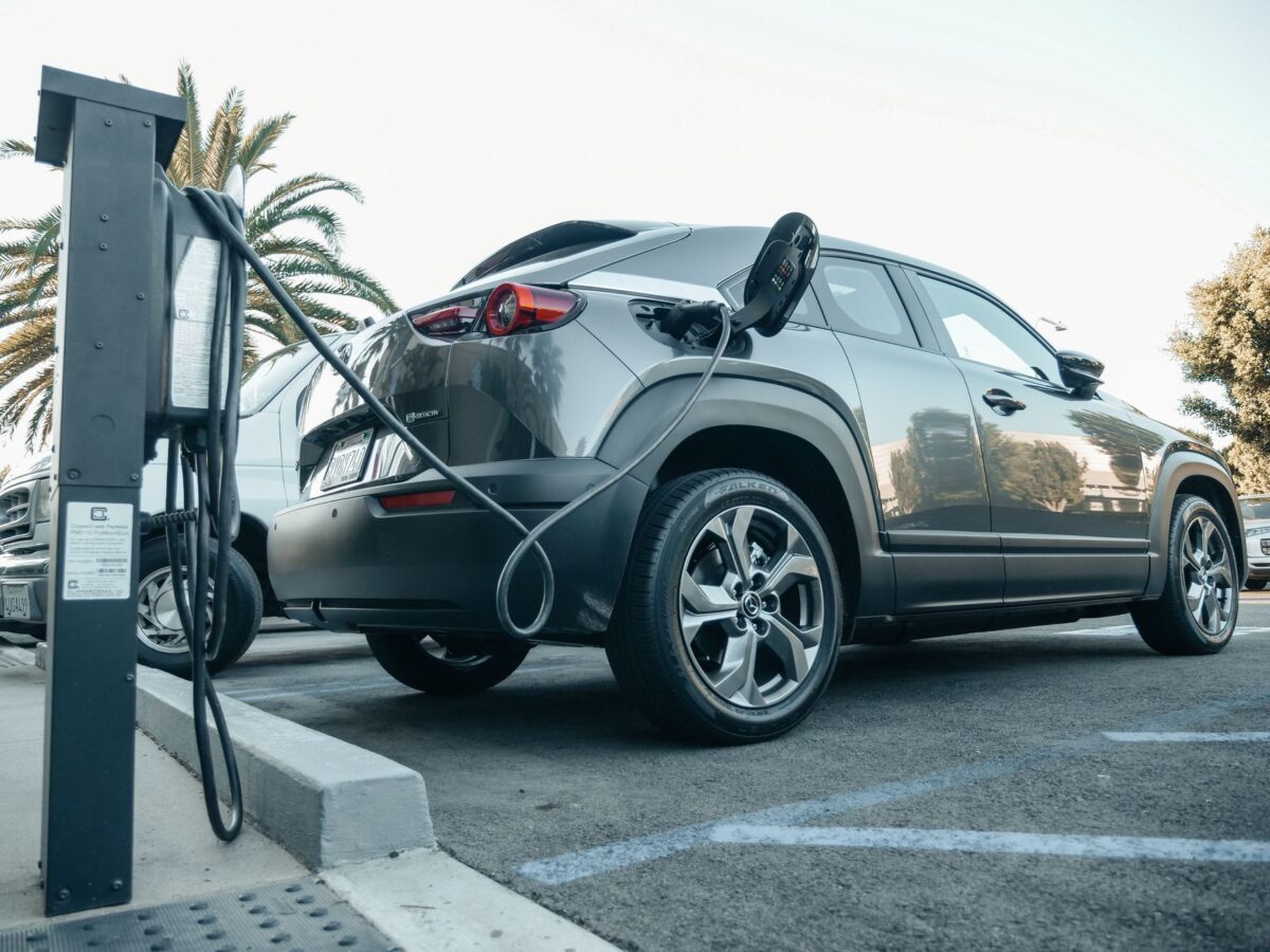 Voiture électrique branchée à une borne de recharge en extérieur