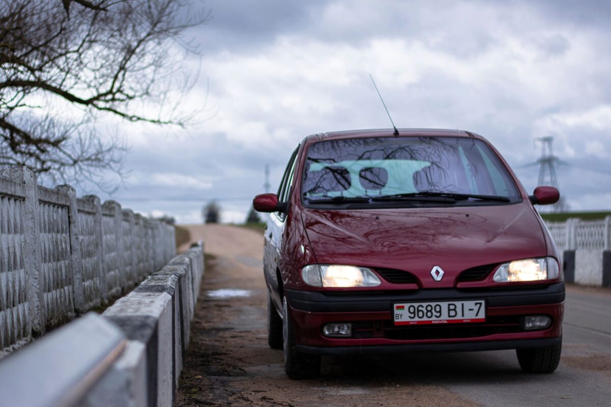 Renault rouge garée au bord d'une route de campagne