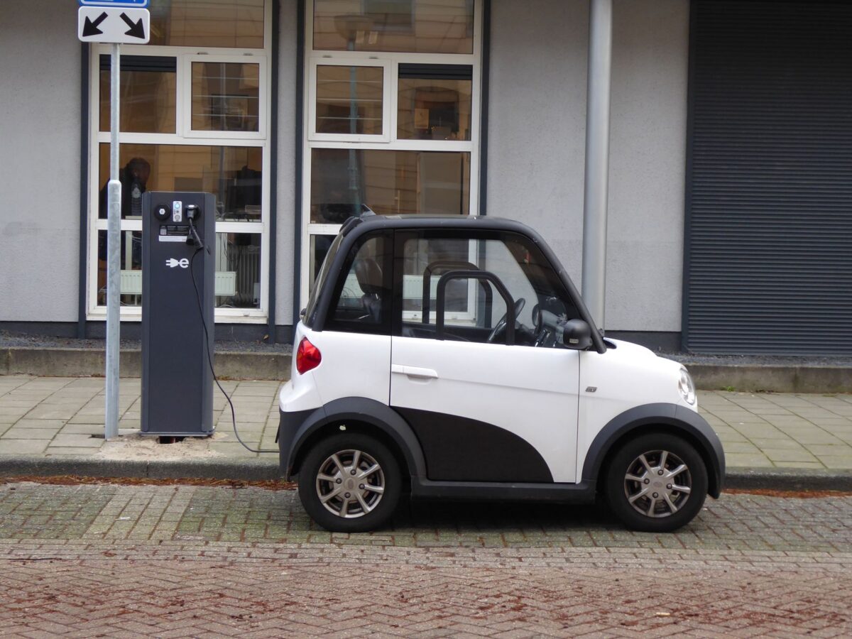 Petite voiture électrique compacte en charge sur une borne publique