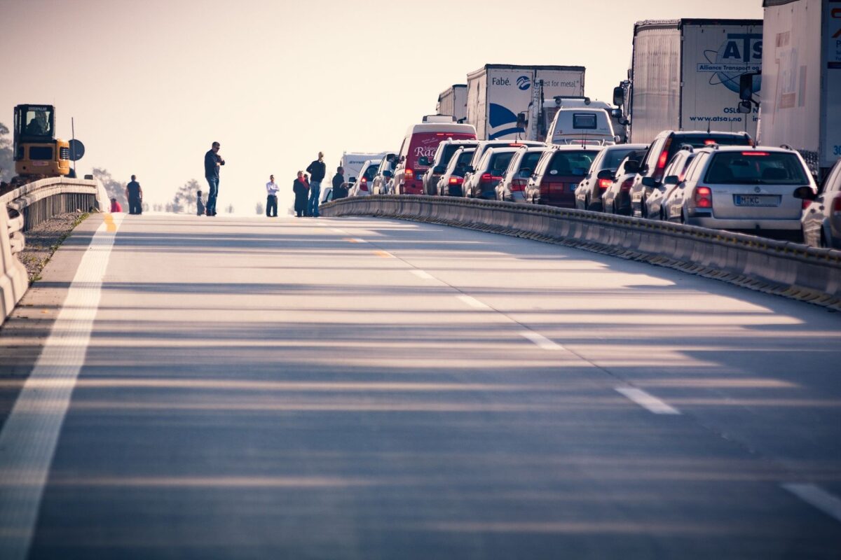 A congested highway with cars and trucks in a traffic jam during daylight.